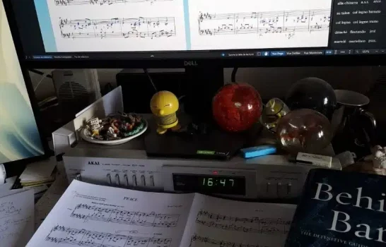 Gravure musicale : partition annotée, logiciel de notation et livres de référence sur un bureau d’éditeur