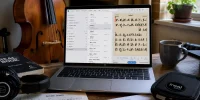 iReal Pro sur Windows affiché sur un ordinateur portable dans un espace de travail de musicien avec contrebasse, casque et partitions.