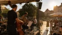 Concert en plein air pendant une canicule avec musiciens sur scène et public cherchant l’ombre